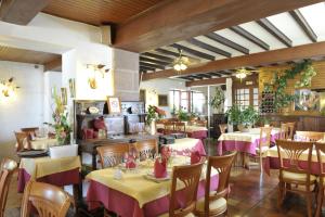 un restaurant avec tables et chaises et nappes roses et jaunes dans l'établissement Hôtel Ramuntcho, à Saint-Jean-Pied-de-Port