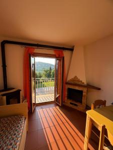 a living room with a fireplace and a sliding glass door at La baita di Marianna in Gamberale