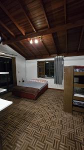 ein Schlafzimmer mit einem Bett und einer Holzdecke in der Unterkunft Casarão até 8 pessoas 400m mar Bombinhas in Bombinhas