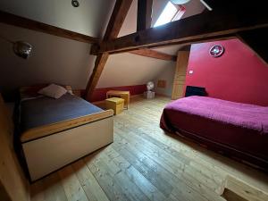 a bedroom with a bed and a red wall at Beau duplex proche centre in Kaysersberg