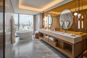 a bathroom with a tub and a sink and mirror at InterContinental Taichung by IHG in Taichung