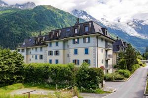 a large white house with mountains in the background at Le Paradis 25 Apartment - Chamonix All Year in Chamonix-Mont-Blanc
