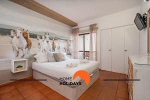 a bedroom with a bed with a picture of horses on the wall at #212 Vila Magna 106B by Home Holidays in Vale de Pedras +29 photos
