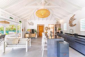 a kitchen and living room with a table and chairs at Villa Bohème in Terre-de-Haut