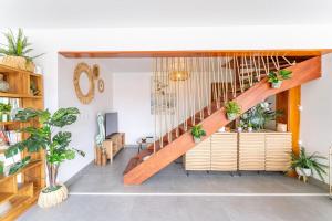 a living room with a wooden staircase with potted plants at Villa Opale in Terre-de-Haut +6 photos