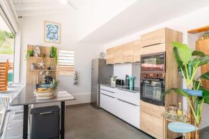 a kitchen with white counters and wooden cabinets at Villa Topaze in Terre-de-Haut