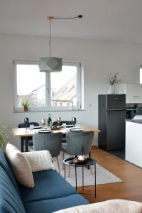 een woonkamer met een blauwe bank en een tafel bij Schwarzwald Lahr Europapark Penthouse Sunshine in Lahr