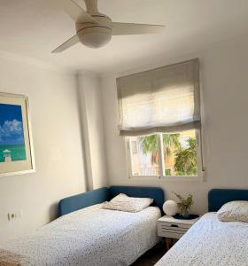 a bedroom with two beds and a window at Open view Pinetree penthouse in Dehesa de Campoamor