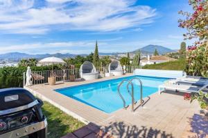 a swimming pool in a yard with a grill at Exclusive Villa Marbella in Marbella