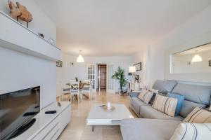 salon z kanapą i stołem w obiekcie LXR La Carihuela Sea Views 3HAB w mieście Torremolinos