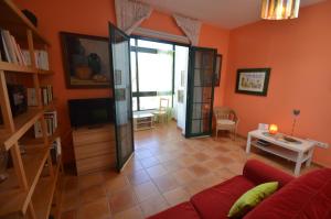 a living room with a red couch and a television at Casa Ana Rosa Good location & Close to the beach in Playa Blanca