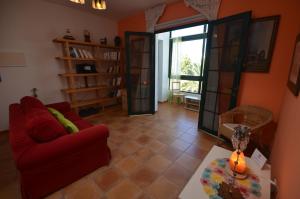 a living room with a red couch and a table at Casa Ana Rosa Good location & Close to the beach in Playa Blanca