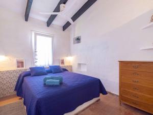 una camera con letto blu e cassettiera di Villa Es Cantell a Binisafua