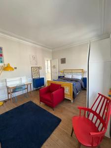 a bedroom with a bed and a red chair at Hôtel Particulier Petit-Decaix in Conty