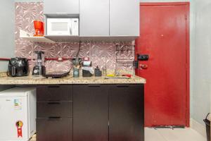 a kitchen with a red door and a red cabinet at Loft Moderno com Ar Condicionado, Estacionamento Gratuito & Wi-Fi Brás, Expo Center Norte e Anhembi in São Paulo