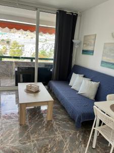 un soggiorno con letto blu e tavolo di La Cascada 410 a Puerto Rico de Gran Canaria