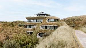 a house clad in grass with a roof at Duinhotel Tien Torens in Zoutelande