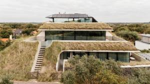 a house with a grass roof at Duinhotel Tien Torens in Zoutelande