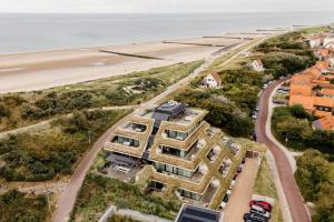 an aerial view of a building next to the beach at Duinhotel Tien Torens in Zoutelande