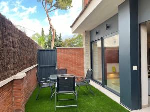 eine Terrasse mit einem Tisch und Stühlen auf dem Rasen in der Unterkunft Beautiful renovated studio in Castelldefels