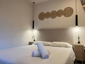 ein weißes Bett mit einem blauen Kissen darauf in der Unterkunft Beautiful renovated studio in Castelldefels