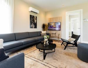 a living room with a couch and a table at Boerderij Villa met Binnenzwembad & Wellness - 10 personen in Wekerom