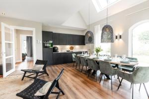 a kitchen and dining room with a table and chairs at Boerderij Villa met Binnenzwembad & Wellness - 10 personen in Wekerom