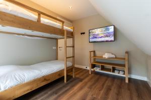 a bedroom with two bunk beds and a flat screen tv at Boerderij Villa met Binnenzwembad & Wellness - 10 personen in Wekerom +69 photos