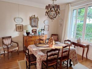 a dining room with a table and chairs and a chandelier at Maison de famille à Millau in Millau