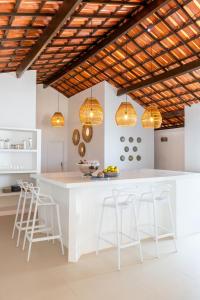 a kitchen with a white counter and stools at Kitesurfing Paradise, Beautiful Beach House in Taíba
