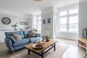 a living room with a blue couch and a table at Sailors Rest in Dartmouth