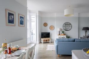 a living room with a blue couch and a table at Sailors Rest in Dartmouth