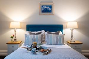 a bed with a tray of food on it with two lamps at Sailors Rest in Dartmouth