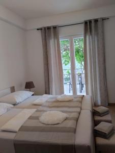 ein Schlafzimmer mit zwei Betten und einem großen Fenster in der Unterkunft Nonna Laura Adriatic dream apartment with sea view in Rabac + 27 Fotos