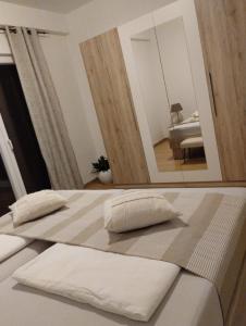 2 weiße Betten in einem Zimmer mit Spiegel in der Unterkunft Nonna Laura Adriatic dream apartment with sea view in Rabac