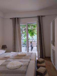 ein Schlafzimmer mit einem großen Bett und einer Glasschiebetür in der Unterkunft Nonna Laura Adriatic dream apartment with sea view in Rabac