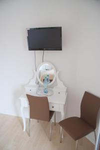 einen weißen Schreibtisch mit einem Spiegel und einem Stuhl in der Unterkunft Aaltine 1 in Bad Bentheim