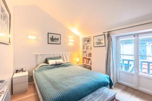 a bedroom with a bed and a window at Appartement Verdun - Welkeys in Biarritz
