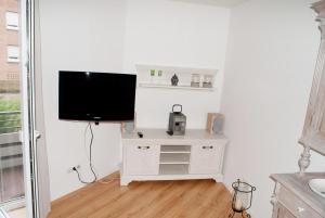 a living room with a tv and a white stand with a television at Aaltine 1 in Bad Bentheim