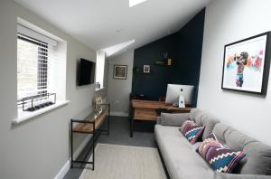 a living room with a couch and a desk at Historic Tring 2 Story Flat on High Street in Tring
