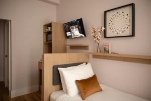 a bedroom with a white bed with a wooden headboard at Bob W London Holland Park in London