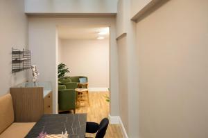 a living room with a table and a green couch at Bob W London Holland Park in London