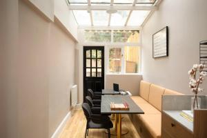 an office with a table and chairs and a window at Bob W London Holland Park in London