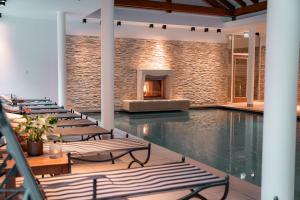an indoor pool with lounge chairs and a fireplace at Das Marienhöh in Langweiler
