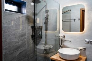 un bagno con lavandino e doccia con specchio di Peak Hotel Kazbegi a Kazbegi Altre 37 foto