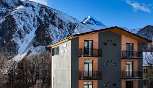 un edificio di fronte a una montagna innevata di Peak Hotel Kazbegi a Kazbegi