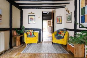 a living room with two yellow chairs and a table at Tranquil Luxe in Country Cottage in Bosham +52 photos