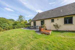 a house with a patio and a grass yard at Peaceful house - SPA - Babyfoot - Forest in Ablon