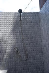 a shower with a shower head in a bathroom at Medukuh Point Hill in Karangasem