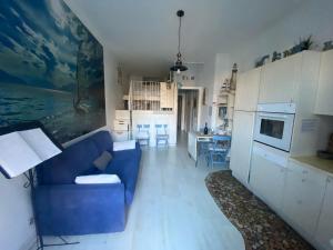 a living room with a blue couch and a kitchen at H&H I Bravi in Malgrate